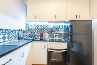 a kitchen with white cabinets and a stainless steel refrigerator at Gorgeous & Modern At Ampelokipi Metro Station By Greece Apartments in Athens
