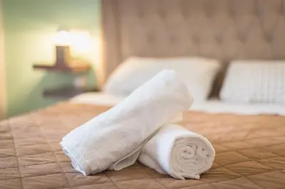 a roll of white towels sitting on a bed at Gorgeous & Modern At Ampelokipi Metro Station By Greece Apartments in Athens