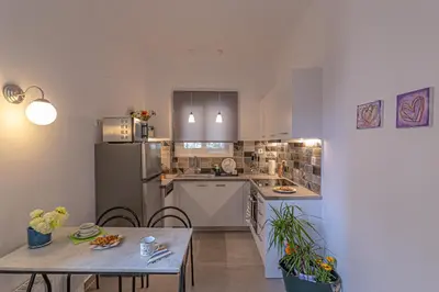 a kitchen with a table and a refrigerator at Marveco Apartment in Athens