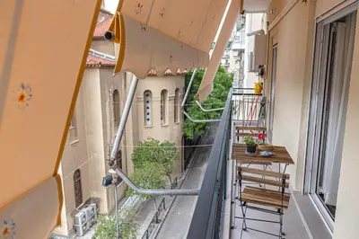 an empty balcony with a table and chairs on a building at Marveco Apartment in Athens