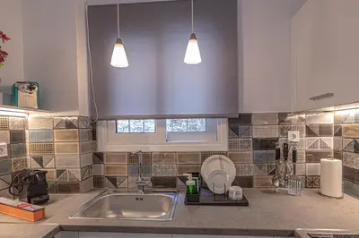a kitchen with a sink and two pendant lights at Marveco Apartment in Athens