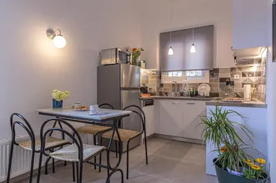 a kitchen with a table and chairs and a refrigerator at Marveco Apartment in Athens