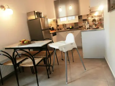 a kitchen with a table and chairs and a refrigerator at Marveco Apartment in Athens