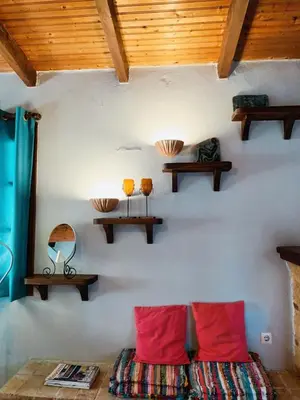 a room with two red pillows and shelves on the wall at Garden's House in Spáta