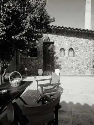 a patio with a table and chairs and a building at Garden's House in Spáta