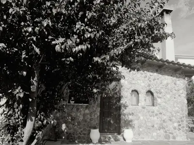 a stone building with a tree in front of it at Garden's House in Spáta