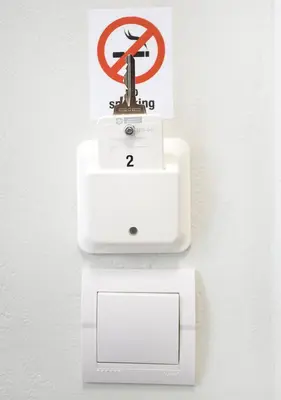 a white sink and a no smoking sign on a wall at Snooze H in Athens