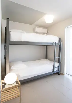 two bunk beds in a room with a table at Snooze H in Athens