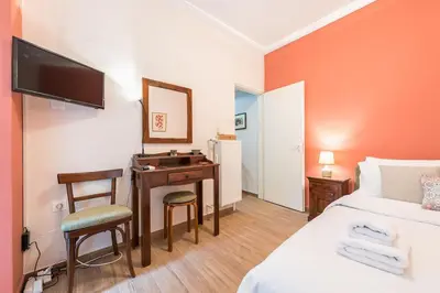 a hotel room with a desk and a bed and a television at Cozy studio 5mins walk from Acropolis museum in Athens