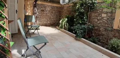a patio with chairs and plants on a wall at Cozy studio 5mins walk from Acropolis museum in Athens