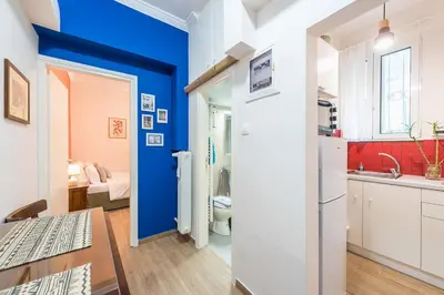a kitchen with blue walls and a table and a sink at Cozy studio 5mins walk from Acropolis museum in Athens