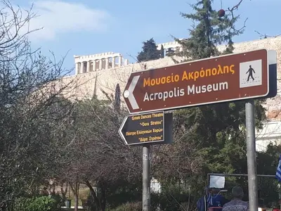 a street sign in front of a building at Cozy studio 5mins walk from Acropolis museum in Athens