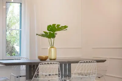 a dining room table with chairs and a vase with a plant at Glyfada Villa 6BR 16ppl Private Pool 300m to Beach in Athens