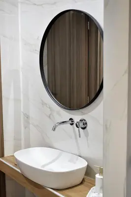 a bathroom with a white sink and a mirror at BEAUTIFUL PEOPLE SUITES ATHENS ACROPOLIS VIEW in Athens