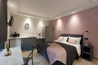 a bedroom with a large bed and a kitchen at 12 Reasons Why Metaxourgeio in Athens