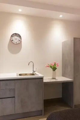 a kitchen with a sink and a clock on the wall at 12 Reasons Why Metaxourgeio in Athens