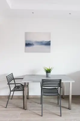 a table with two chairs and a potted plant on it at 12 Reasons Why Metaxourgeio in Athens