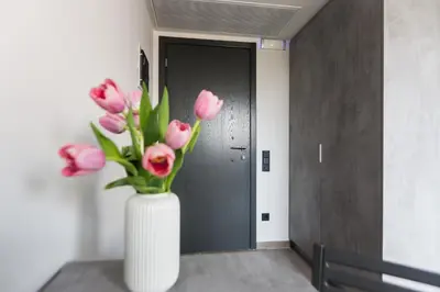 a white vase with pink flowers in a hallway at 12 Reasons Why Metaxourgeio in Athens