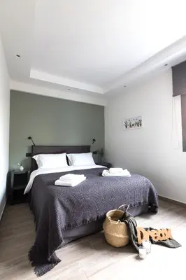 a bedroom with a large bed and a basket on the floor at 12 Reasons Why Metaxourgeio in Athens