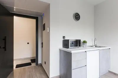 a kitchen with a microwave on a counter next to a door at 12 Reasons Why Metaxourgeio in Athens