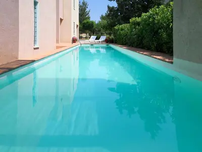a swimming pool with blue water in a house at Villa Rosa with private pool, Athens Riviera in Kalívia Thorikoú