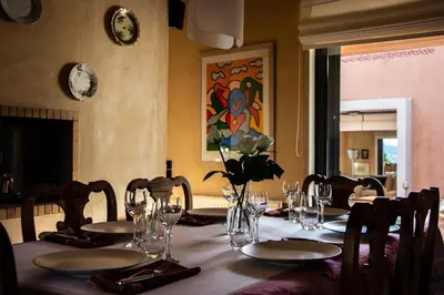 a table with chairs and glasses and flowers on it at Villa Rosa with private pool, Athens Riviera in Kalívia Thorikoú