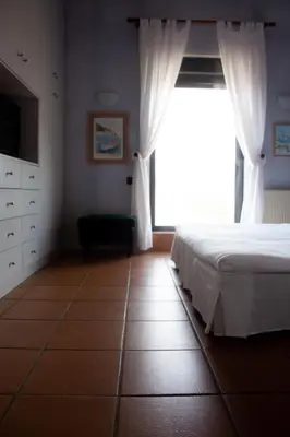 a bedroom with a bed and a large window at Villa Rosa with private pool, Athens Riviera in Kalívia Thorikoú
