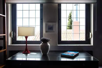 a table with a lamp and a book and a window at Villa Rosa with private pool, Athens Riviera in Kalívia Thorikoú