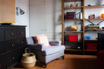 a living room with a chair and a shelf at Villa Rosa with private pool, Athens Riviera in Kalívia Thorikoú