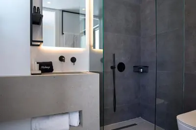 a bathroom with a shower and a toilet and a sink at The Alex Monte Kastella, Santikos Collection in Piraeus