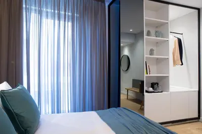 a bedroom with a bed and a large window at The Alex Monte Kastella, Santikos Collection in Piraeus