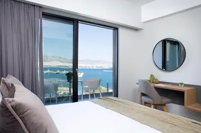 a bedroom with a bed and a view of the ocean at The Alex Monte Kastella, Santikos Collection in Piraeus