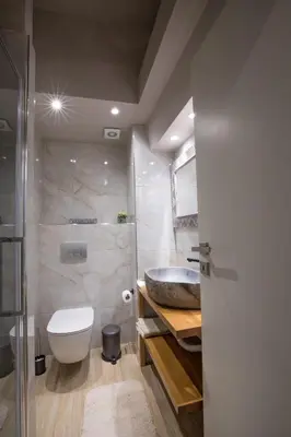a bathroom with a white toilet and a sink at Rastoni Athens Suites near Acropolis at Tsatsou street in Athens
