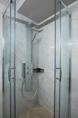 a shower with a glass door in a bathroom at Rastoni Athens Suites near Acropolis at Tsatsou street in Athens