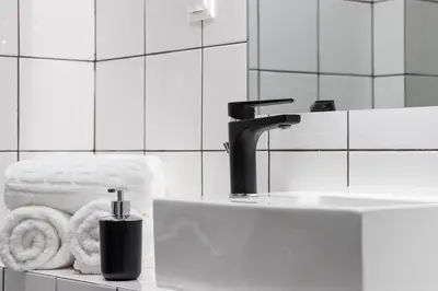 a bathroom with a sink and a faucet and towels at Urban Athens Apartment in Athens
