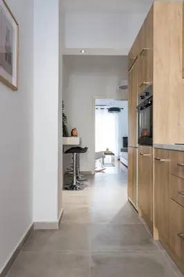 a kitchen with white walls and wooden cabinets at Urban Athens Apartment in Athens