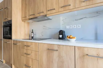 a kitchen with wooden cabinets and a bowl of fruit at Urban Athens Apartment in Athens
