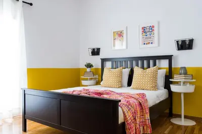 a bedroom with a bed with yellow and white walls at Urban Athens Apartment in Athens
