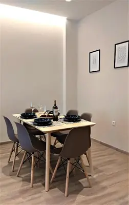 a dining room table with chairs and wine glasses at More Athens Apartments in Athens