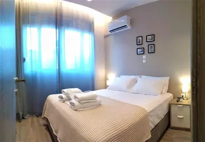 a bedroom with a bed with towels on it at More Athens Apartments in Athens