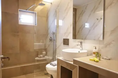 a bathroom with a sink and a toilet and a shower at More Athens Apartments in Athens