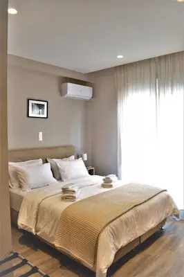 a bedroom with a large bed with a window at More Athens Apartments in Athens