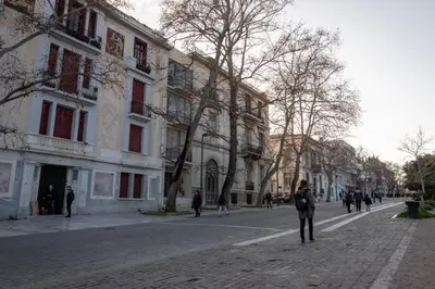 a person standing on a cobblestone street next to a building at Paradise apartment in Koukaki in Athens