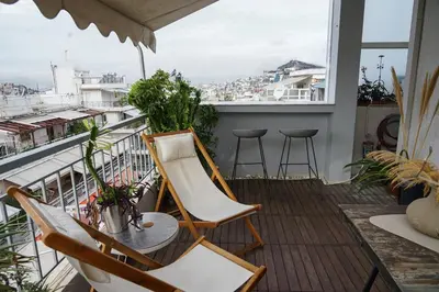 a balcony with chairs and a table and a view at Small & cozy with Acropolis & Lycabettus view in Athens