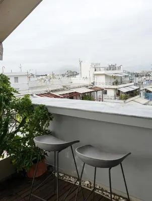 two stools sitting on a balcony overlooking a city at Small & cozy with Acropolis & Lycabettus view in Athens