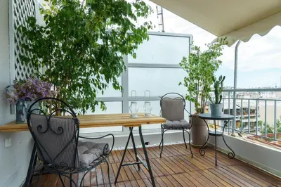 a balcony with a wooden table and chairs at Small & cozy with Acropolis & Lycabettus view in Athens