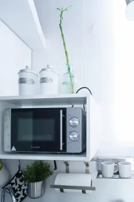 a microwave in a kitchen with cups and plants at Small & cozy with Acropolis & Lycabettus view in Athens