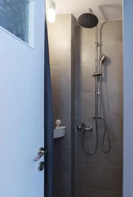 a shower with a shower head in a bathroom at Small & cozy with Acropolis & Lycabettus view in Athens