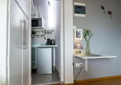 a small kitchen with a counter and a table at Small & cozy with Acropolis & Lycabettus view in Athens