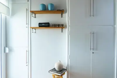 a room with white cabinets and wooden shelves at Small & cozy with Acropolis & Lycabettus view in Athens